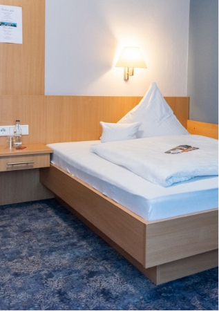 Gemütliches Bett in einem Einzelzimmer des Parkhotel Sonnenhaus